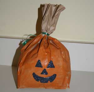 How can you decorate paper bags for Halloween?